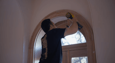 Field & Beam craftsman installing custom arch trim